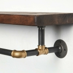 raw steel industrial pipe shelf with brass elbows, hanging rail and dark wood reclaimed shelf