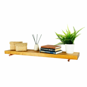 Copper floating shelf brackets holding shelf and books angle left